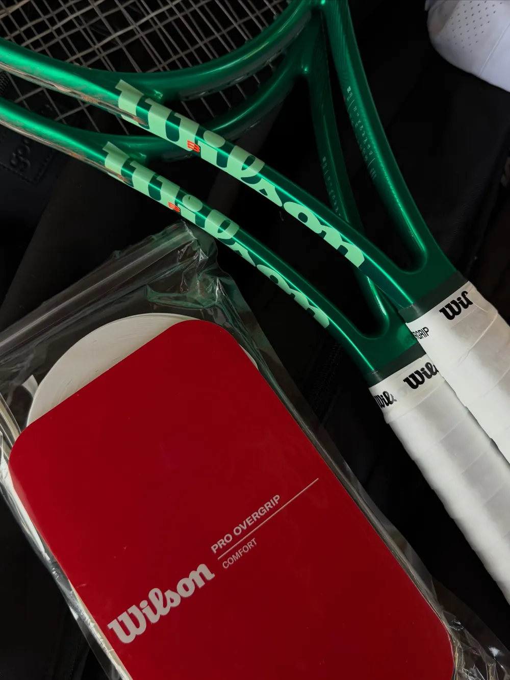 Raquetes Wilson verdes e um overgrip Wilson vermelho
